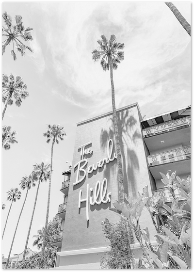 Black and white photo of The Beverly Hills Hotel sign with tall palm trees against the sky